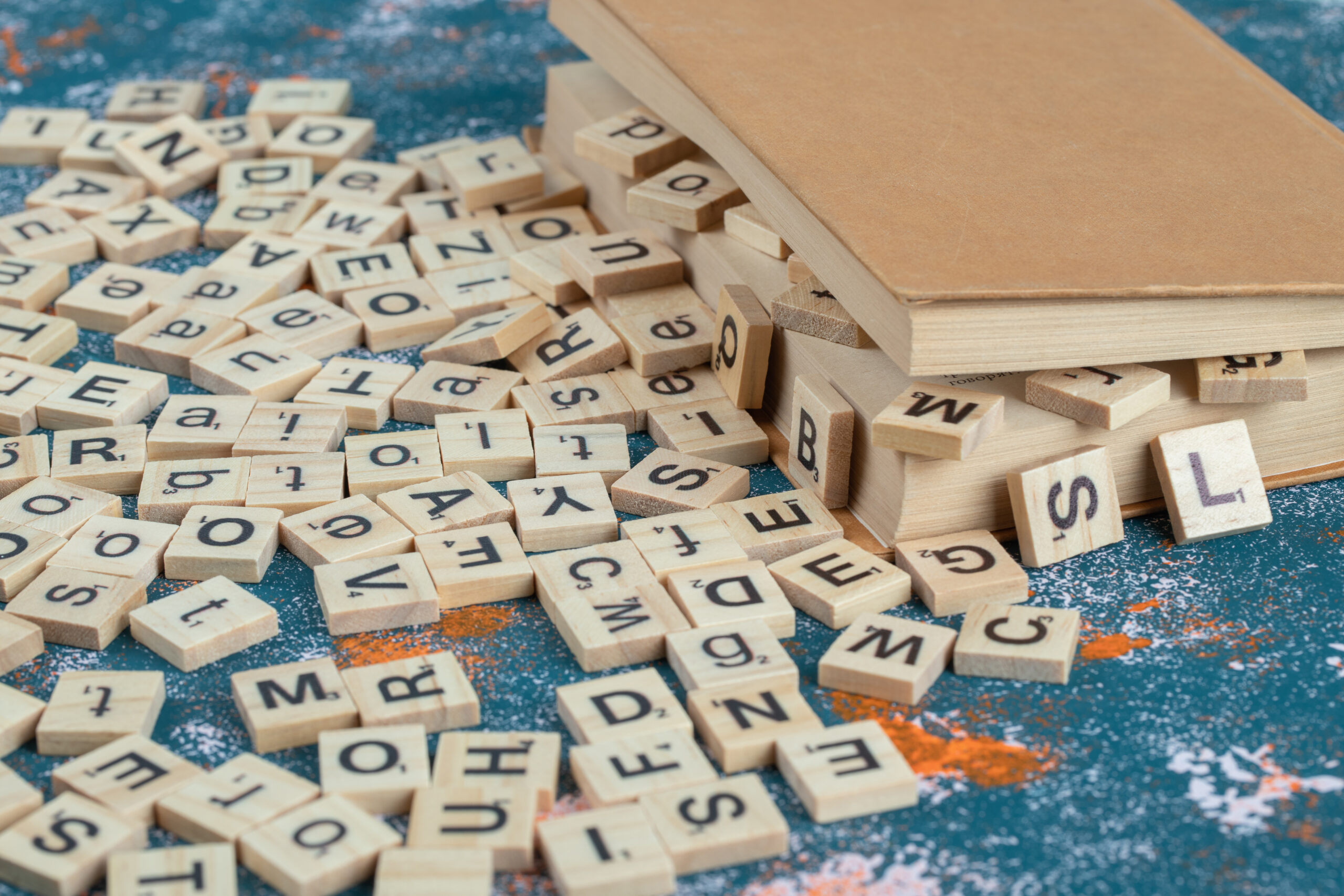 Wooden dice with letters on them between the pages of a book