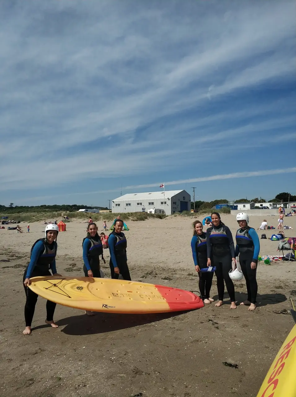 Alumnas de Impulse English con neopreno y paddle surf en una playa de Irlanda